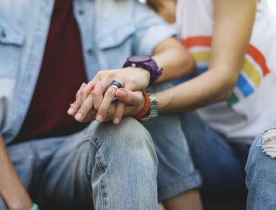 Couple holds hands.