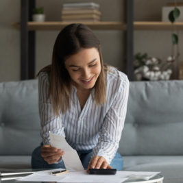 woman sitting on the couch working on personal finance and financial anxiety