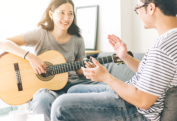 Woman plays guitar in music therapy session